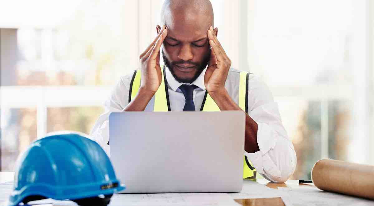 Headache, laptop, and architect man’s stress due to construction industry issues.