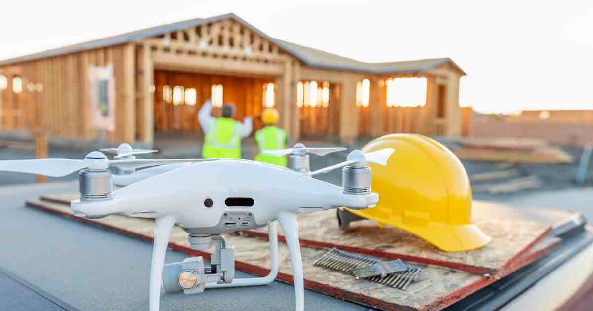 Drone quadcopter next to a hard hat, showing technology in construction.